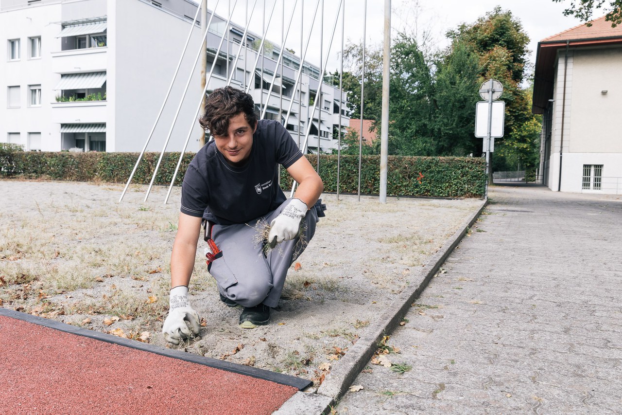 Fachmann Betriebsunterhalt Fachrichtung Hausdienst beim Säubern eines Sportplatzes