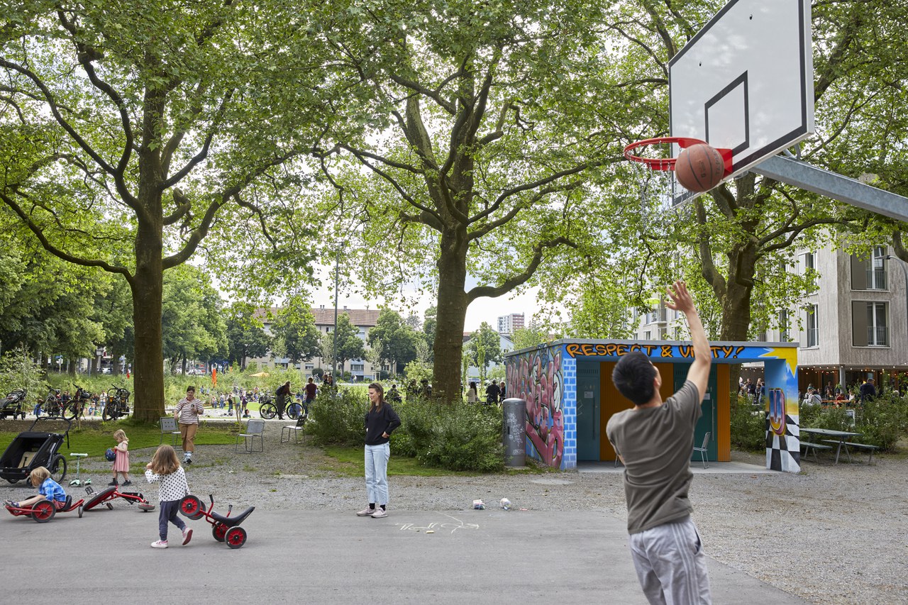 Ein junger Mensch wirft einen Ball in einen Basketballkorb.